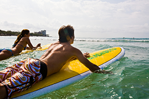 Couple going surfing off Waikiki Beach